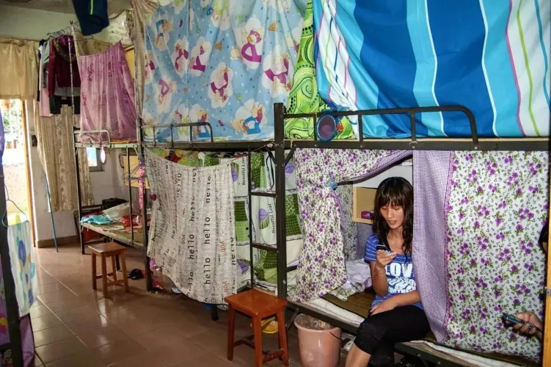 2010年5月26日，广东东莞某工厂集体宿舍。每间十几平方米，里面往往要住10个人以上，很多打工人会在床四周围上一圈布帘，为自己圈出一小方相对隐私的空间。