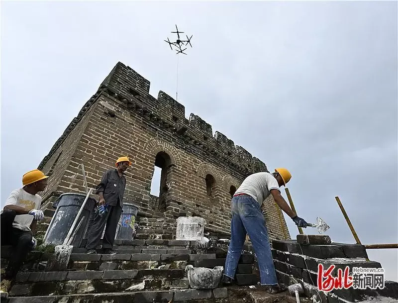 老外游长城遇无人机吊运材料纷纷惊叹，还现学铺青砖体验“修长城”