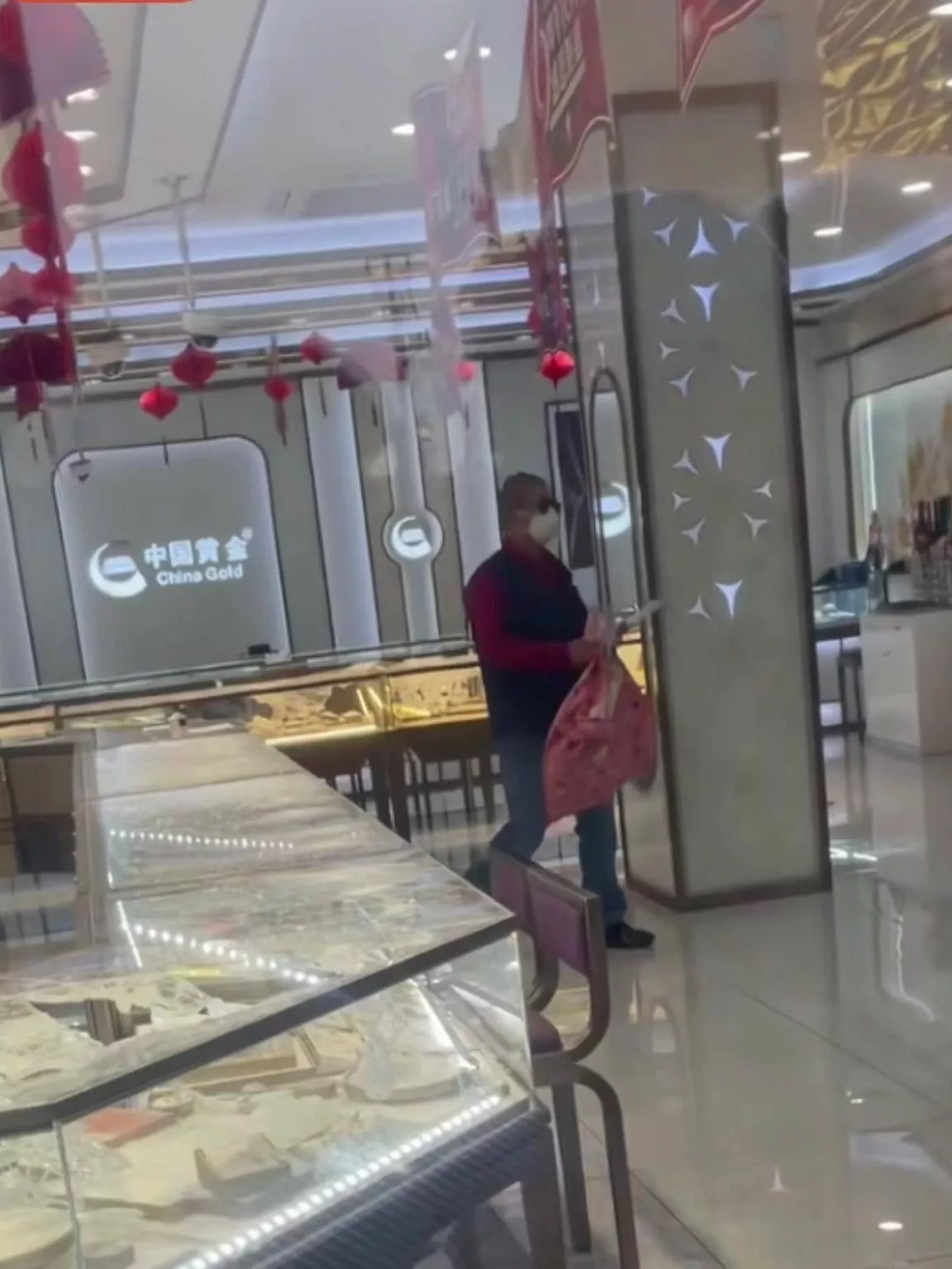 男子拿口袋抢劫上海一金店，多人在店外围观