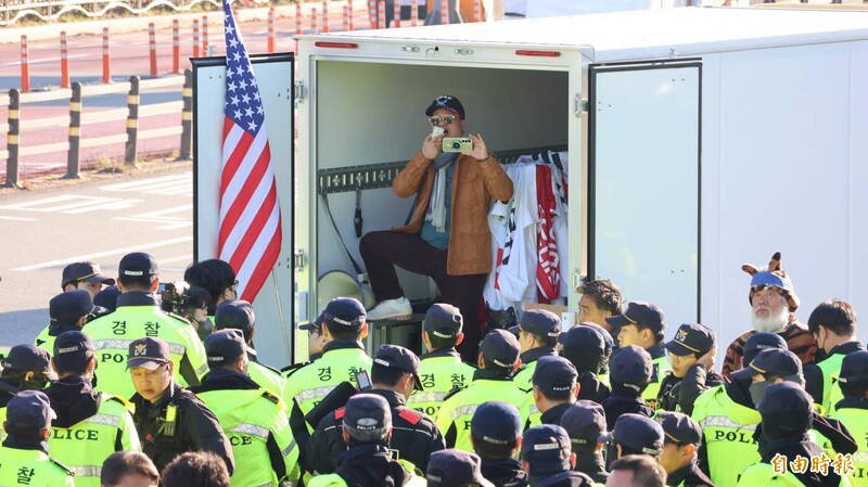美國總統川普與中國國家主席習近平今天將在釜山金海機場會晤,兩人到場前,場外已有抗議群眾舉美國國旗、高喊口號,還有大批警力戒備。(記者黃靖媗攝)