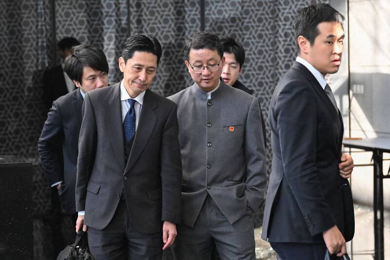 金井正彰（左）在北京与刘劲松（右）会谈时，刘劲松双手插口袋，金井则低头致意，遭中方大作文章。（法新社）