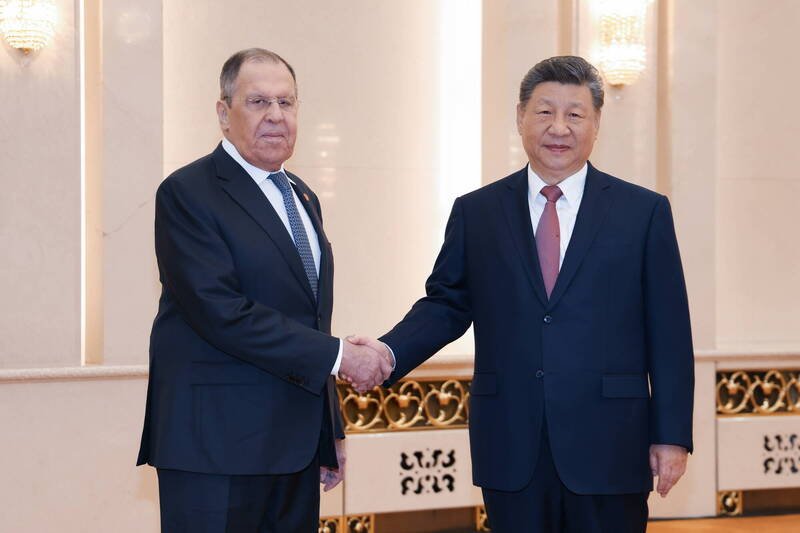 中国国家主席习近平（右）今在北京接见来访的俄罗斯外长拉夫罗夫。（欧新社）
